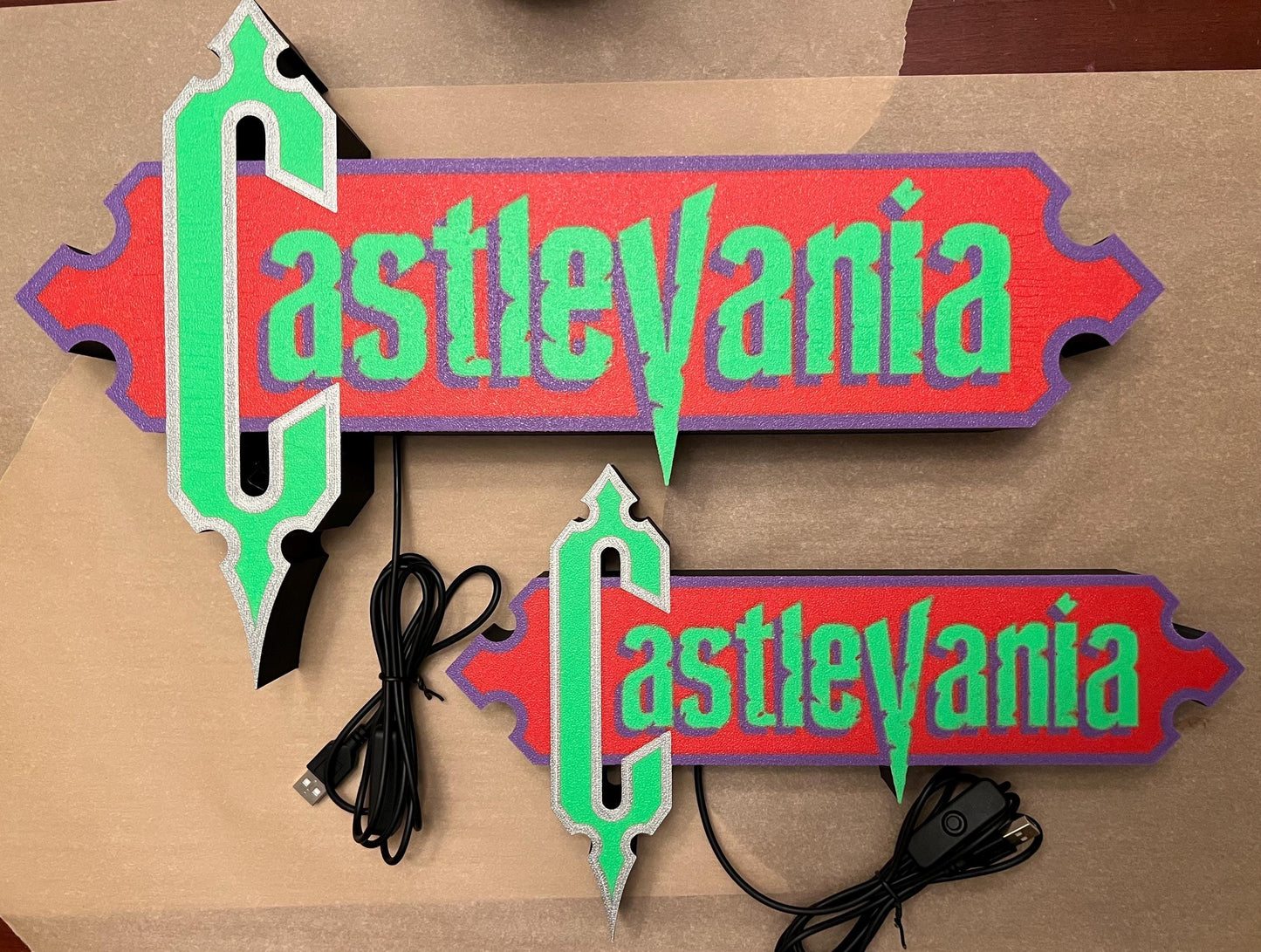Size comparison of the two Castlevania (1986) Inspired 3D Wall Sign, Desk Display, or Shelf Souvenir which is internally illuminated with high density LEDs and USB powered. Purchase available for limited time.